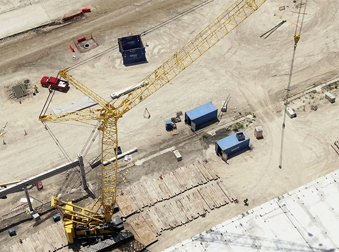 Une grue avec une tour jaune sur un chantier de construction