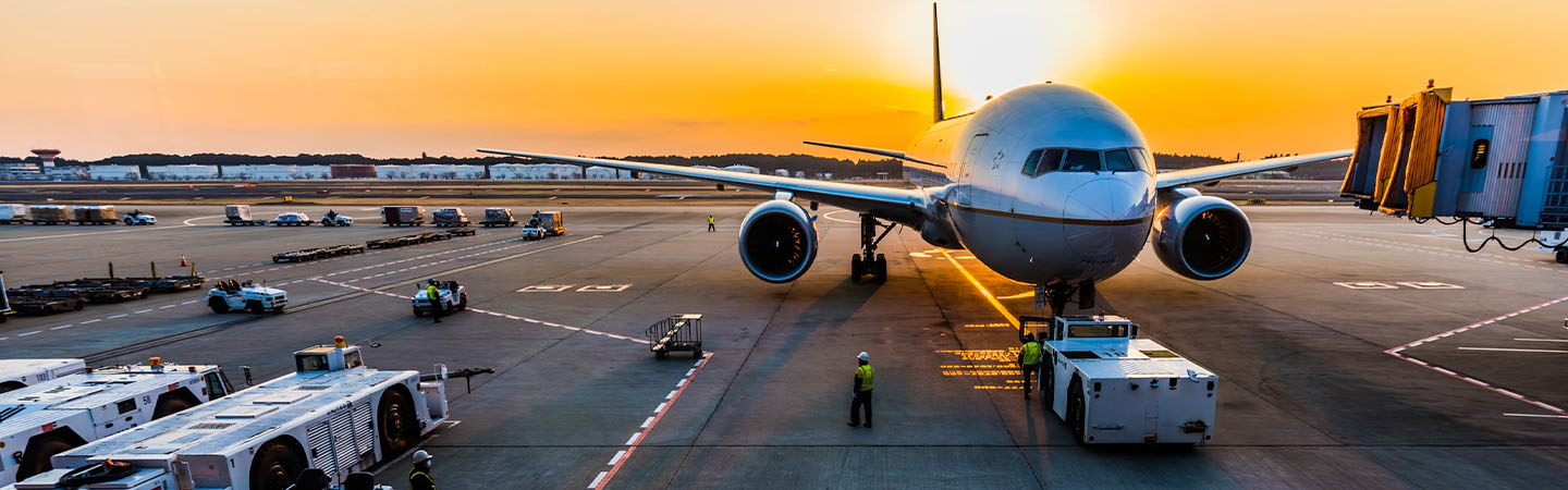 Un avion au sol dans un aéroport au coucher du soleil