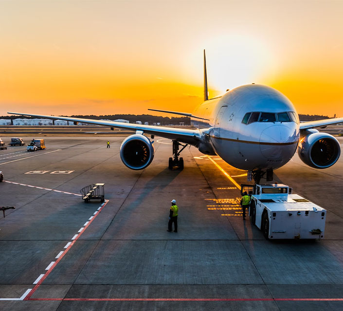 Un avion au sol dans un aéroport au coucher du soleil