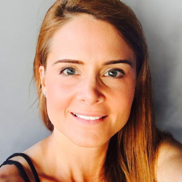 Rachel Neal​​​​ VP Global Safety smiling with long hair on a neutral background.